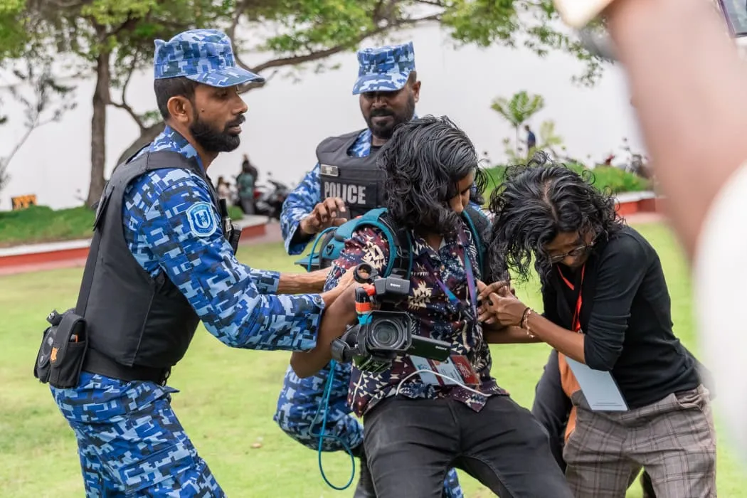 Police officer pushing the journalists---Picture : Adhadhu